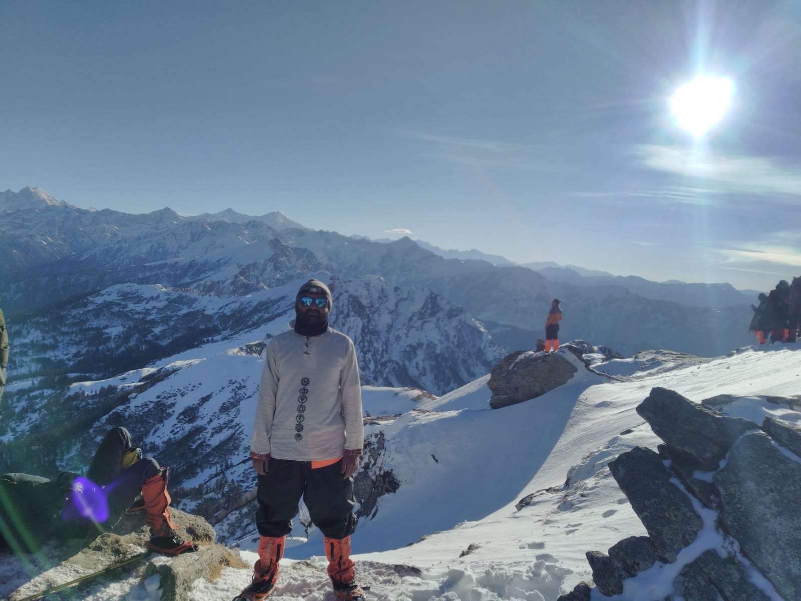 Trekkers crossing a sunny snow ridge